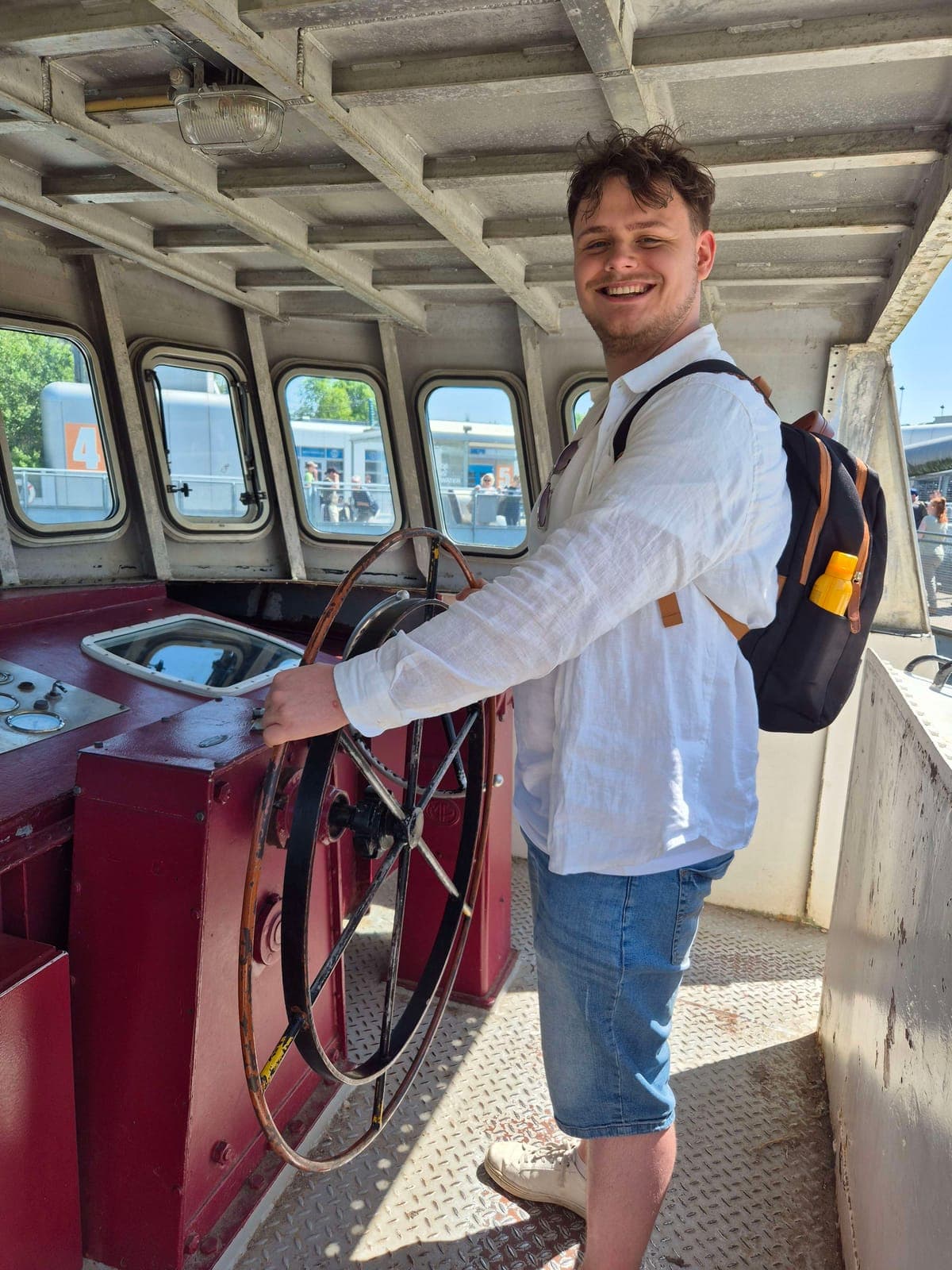 Jamey Weber laughing behind the wheel of an old ferry